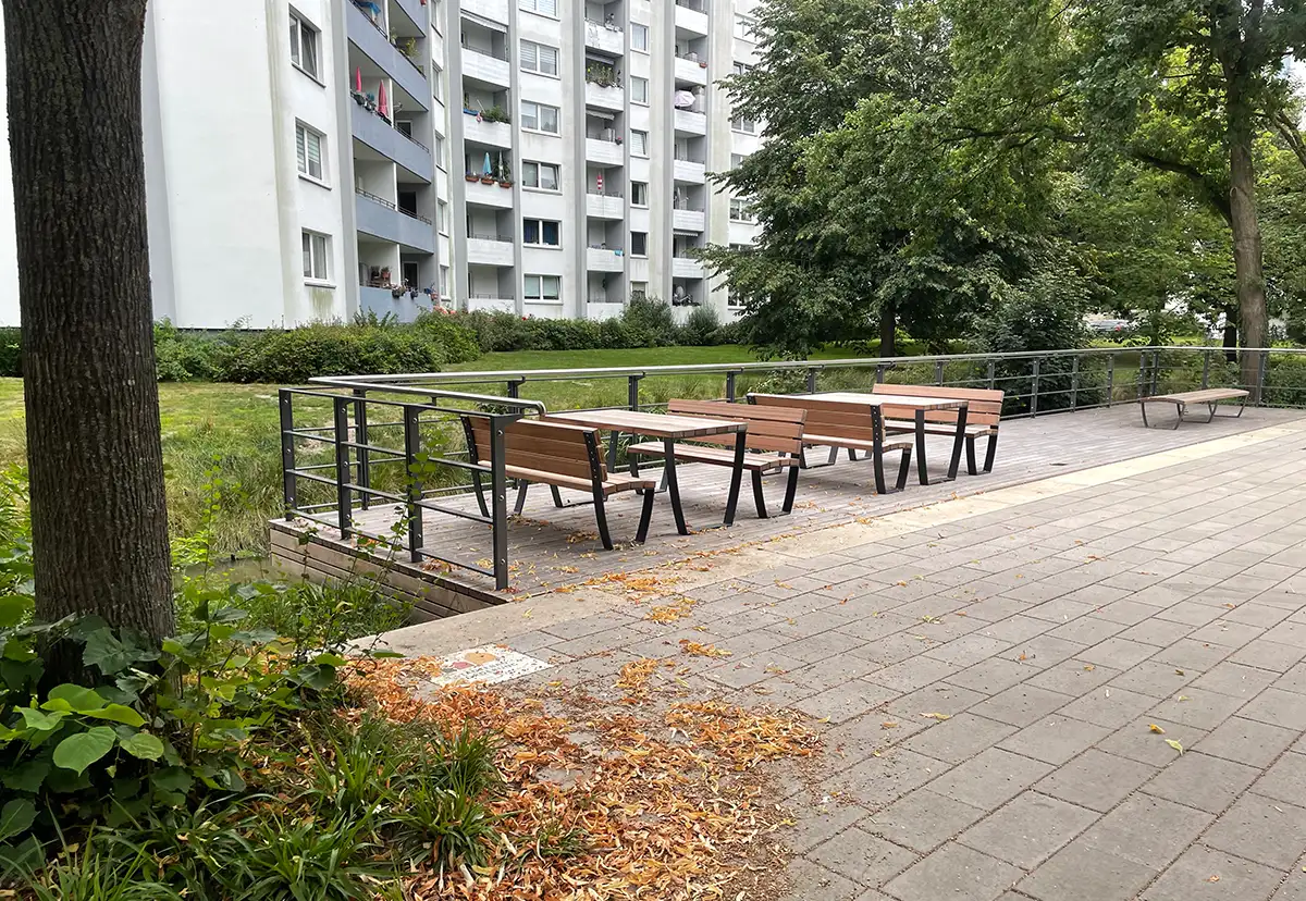 Erweiterung des Spazierwegs mit neuen Holzbänken und -tischen mit Metallzaun zum kleinen Kanal daneben