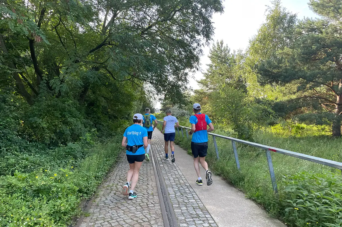 Laufgruppe mit blauen Shirts in einem Park