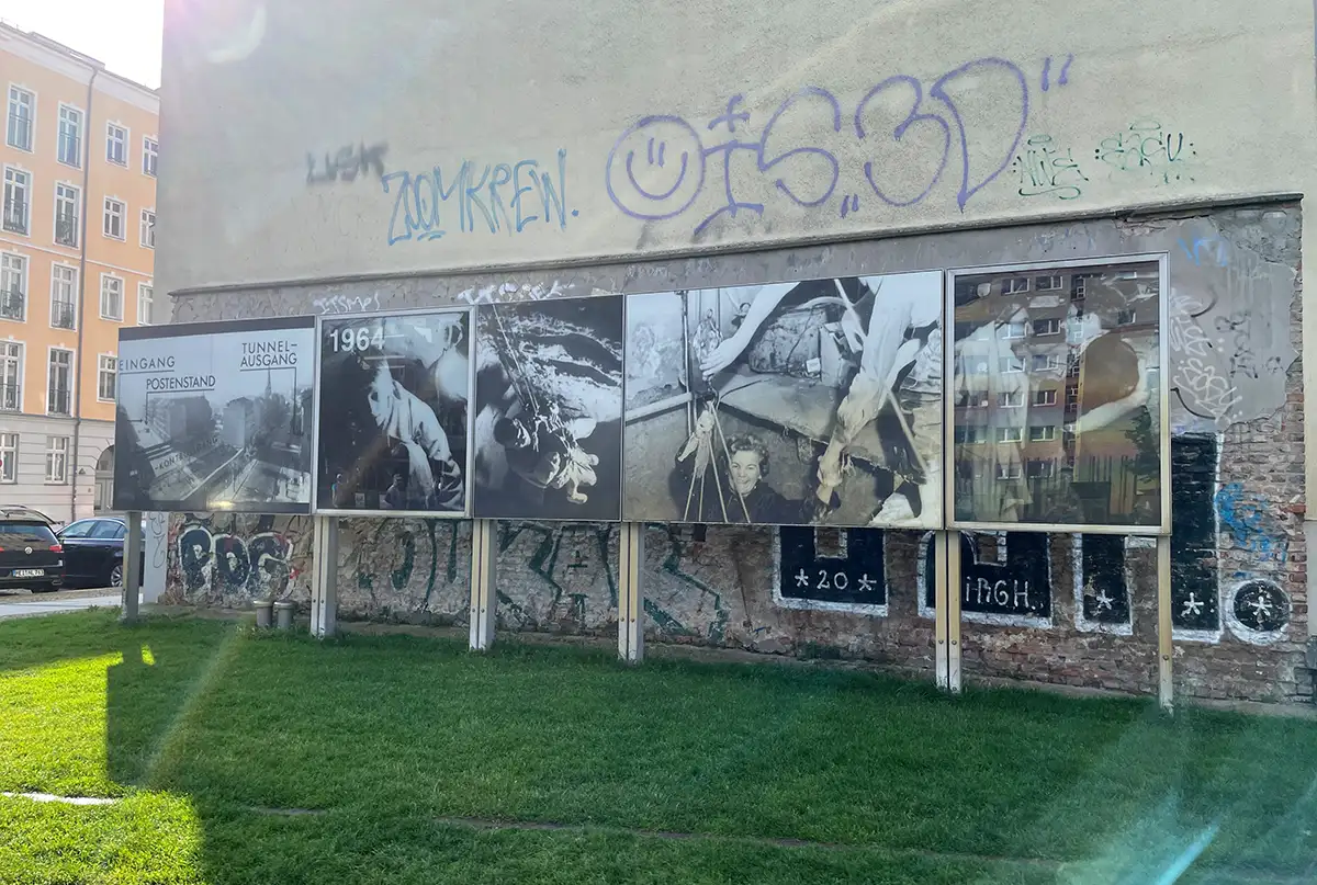 Große Fotos an einer Hauswand, die Szenen von Tunnelfluchten zeigen
