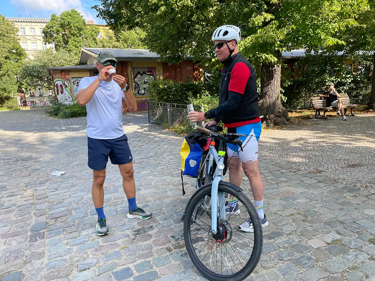 Radbegleiter verteilt Getränke an die Läufer