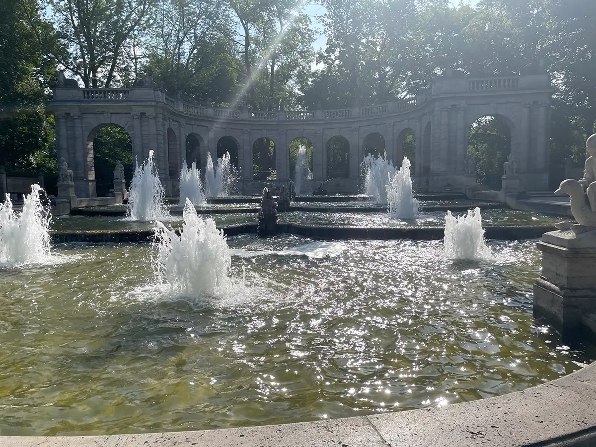 Märchenbrunnen mit Wasserspielen, das Wasser des Beckens glitzert in der Sonne