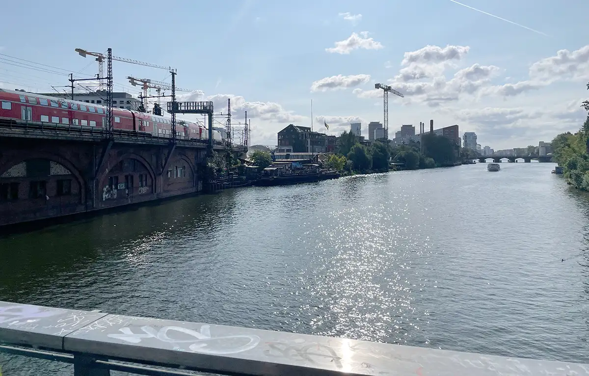 Blick von der Michaelbrücke auf die Bahntrasse und den Club Kater Blau am Ufer der Spree