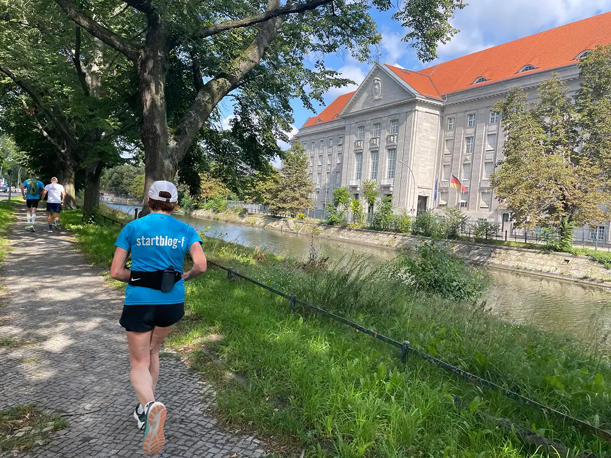 Läuferin auf Uferweg, am anderen Ufer ein Gebäude des Verteidigungsministeriums