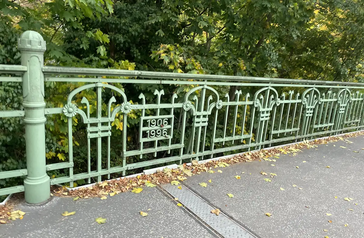 Lindgrünes Jugendstil-Metallgitter an einer Brücke