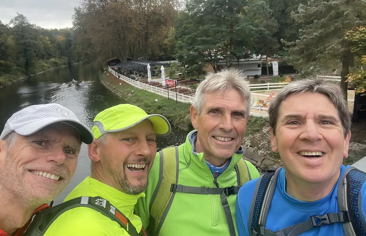 Gruppen-Selfie auf der Brücke mit Blick auf einen Ausflugs-Biergarten am Ufer