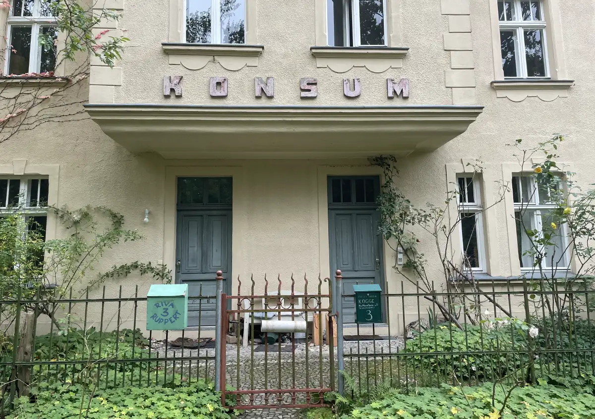 Haus mit Beschriftung „Konsum“ über dem Eingang