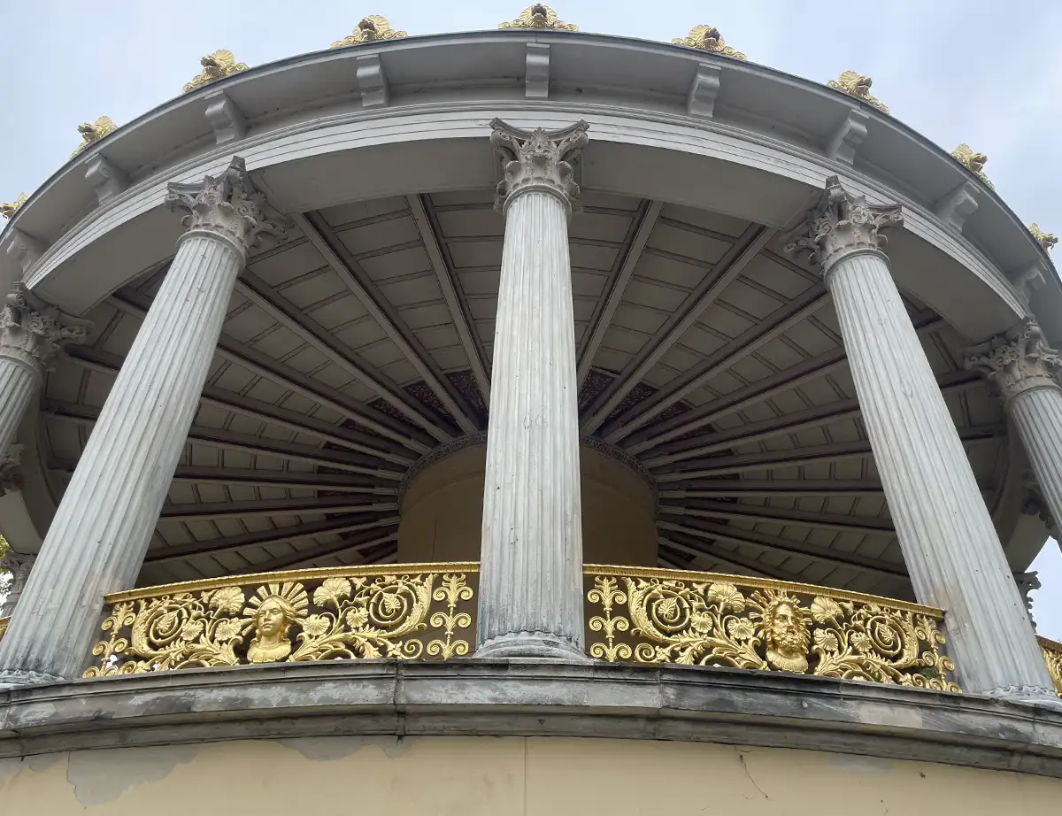 Runder Turm mit Säulen und goldenem Gitter mit kunstvollen Ornamenten
