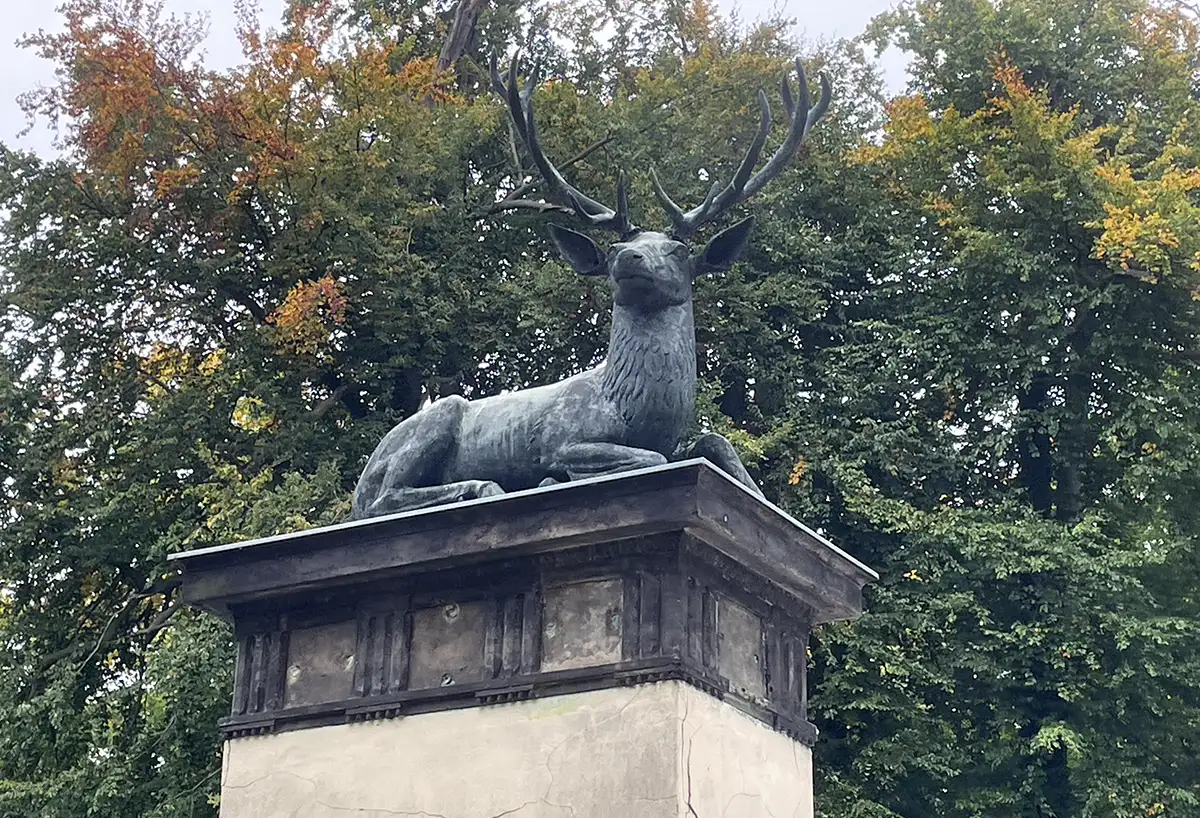 Statue liegender Hirsch auf einem Torpfeiler