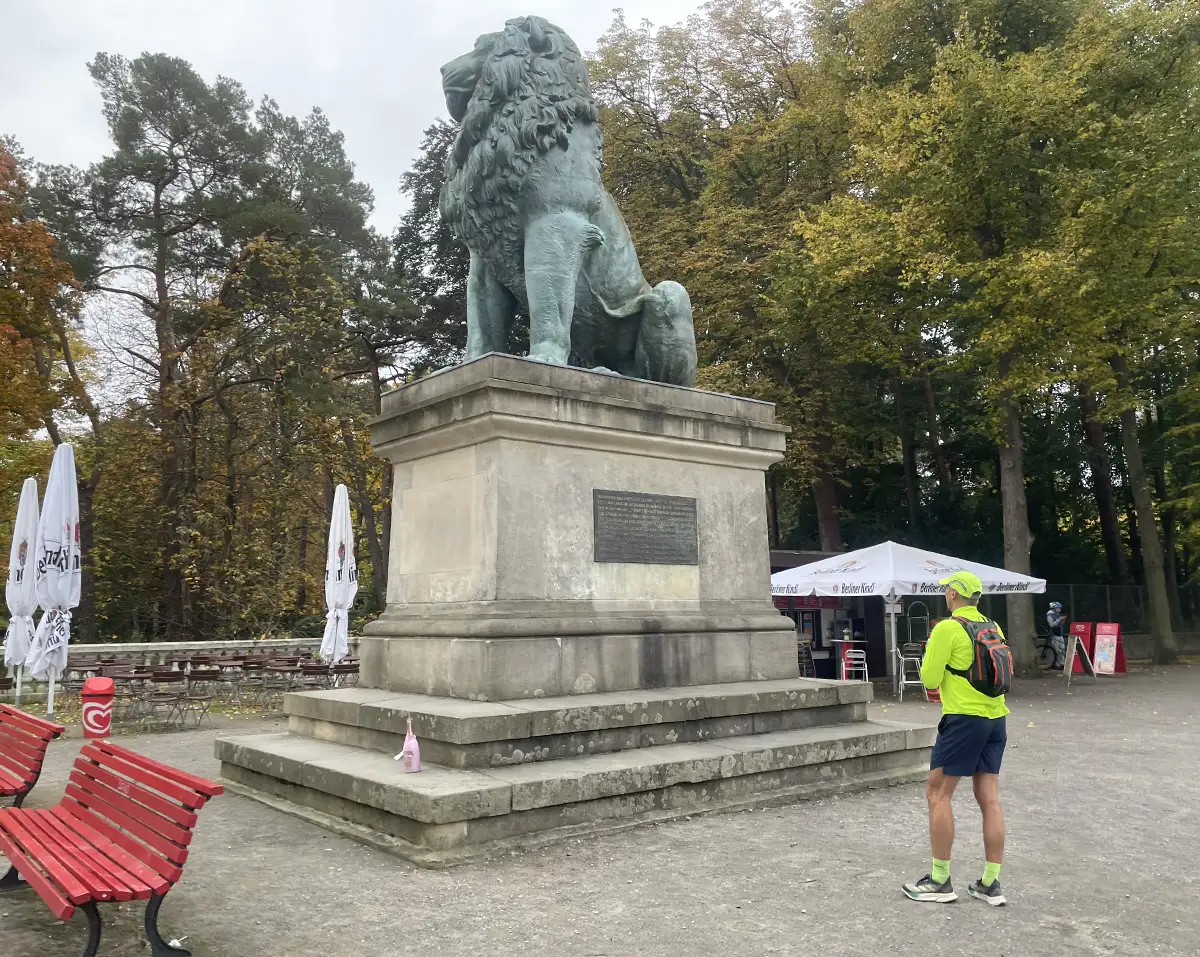 Ein Läufer betrachtet das große Bronze-Denkmal Flensburger Löwe