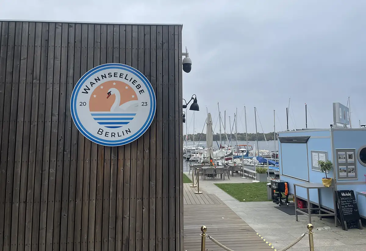 Rundes Schild „Wannseeliebe Berlin“ an einem Holzgebäude