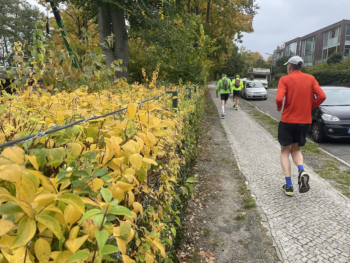 Läufer laufen einen Fußweg an einer Straße hinauf