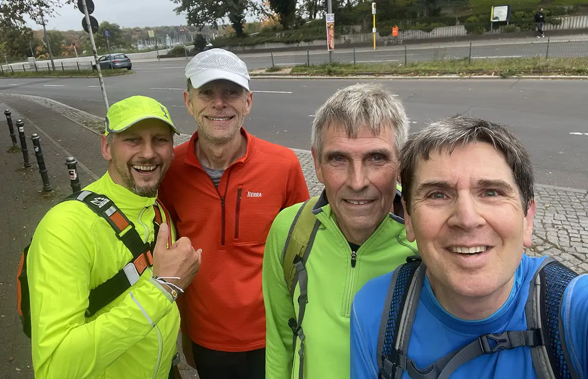Gruppenselfie der 4 Läufer an einer Straße