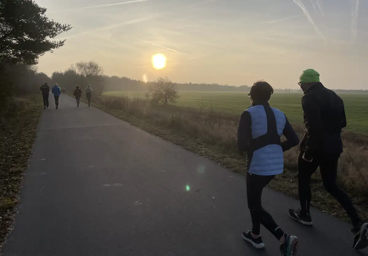 Läuferin und Läufer auf dem asphaltierten Berliner Mauerweg