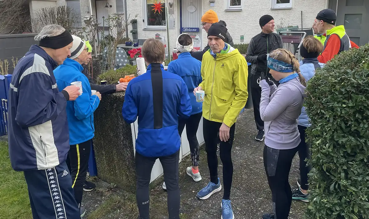 Laufgruppe macht Pause mit Heißgetränken und Weihnachtsgebäck