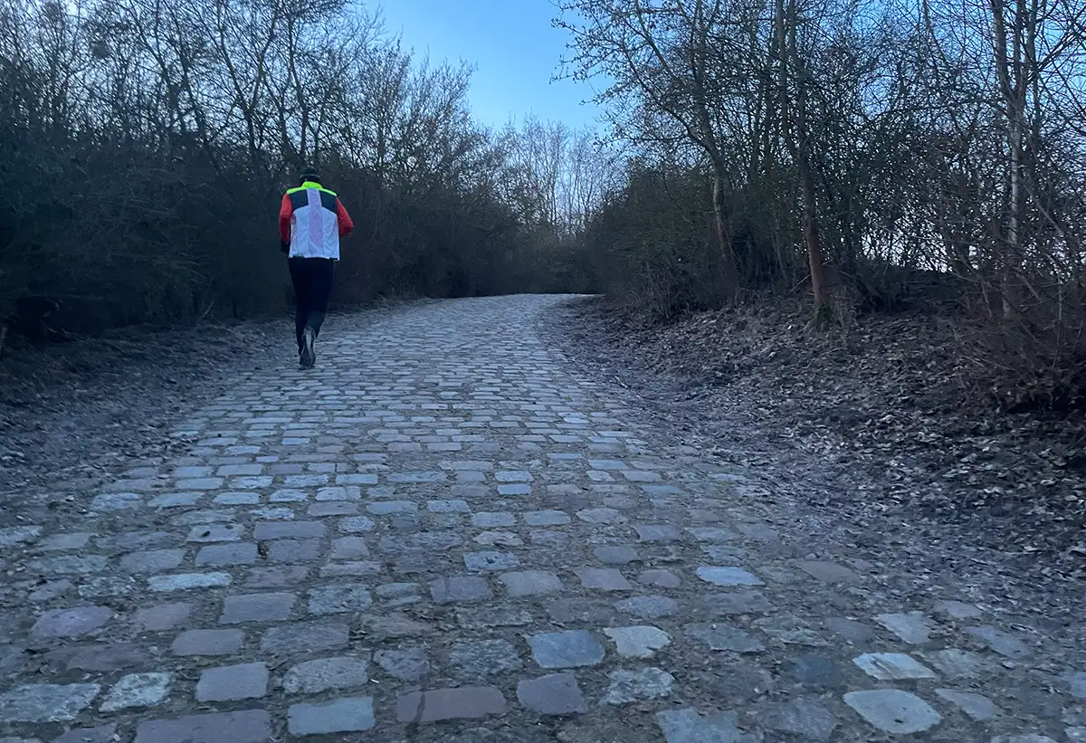 Läufer läuft eine Steigung im Park hinauf