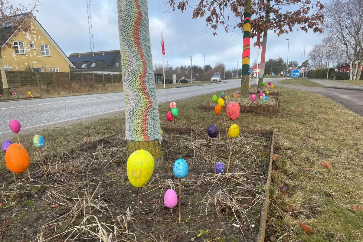 Bemalte Ostereier und bunt umstrickte Bäume