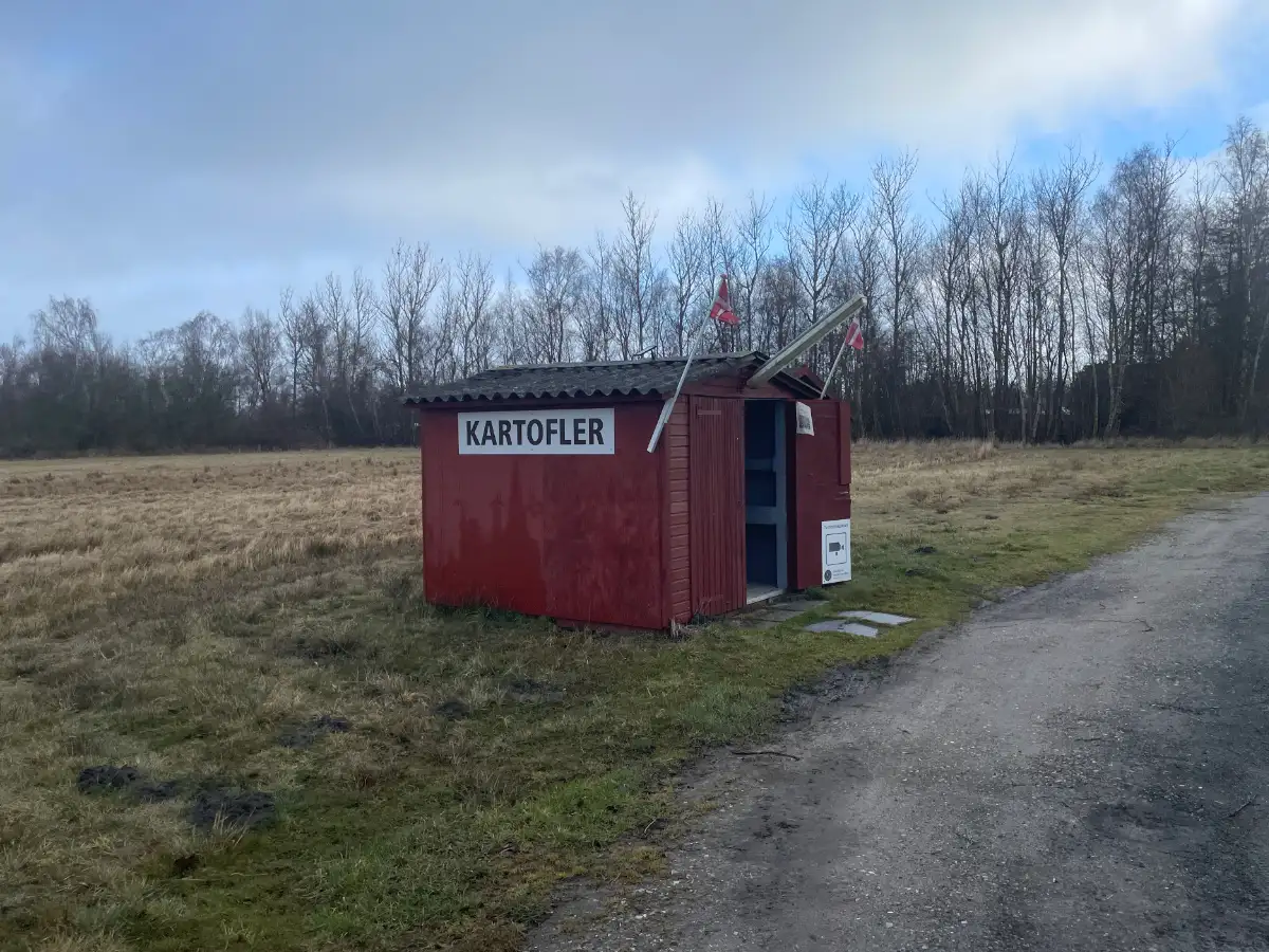Holzhütte mit dänischen Flaggen und Schild Kartofler