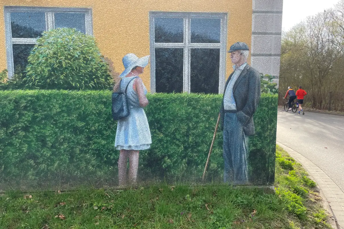 Bemalte Hauswand mit Frau im Sommerkleid und Mann, dahinter Läufer und Radbegleiter