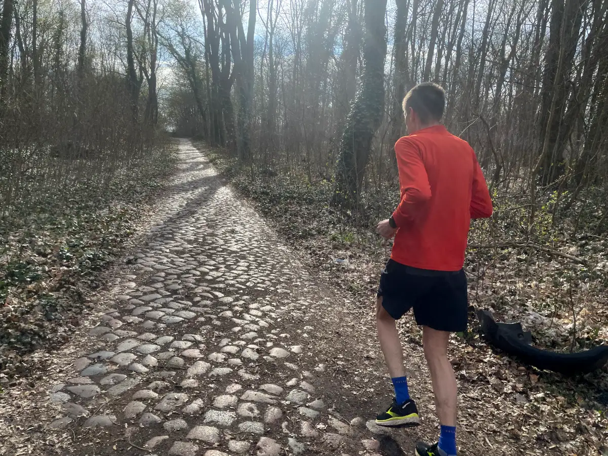 Läufer läuft über Kopfsteinpflaster in einem Waldstück