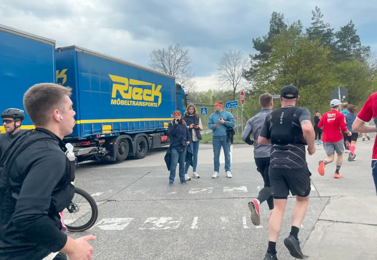 Eine Dreiergruppe steht am Rand und feuert an