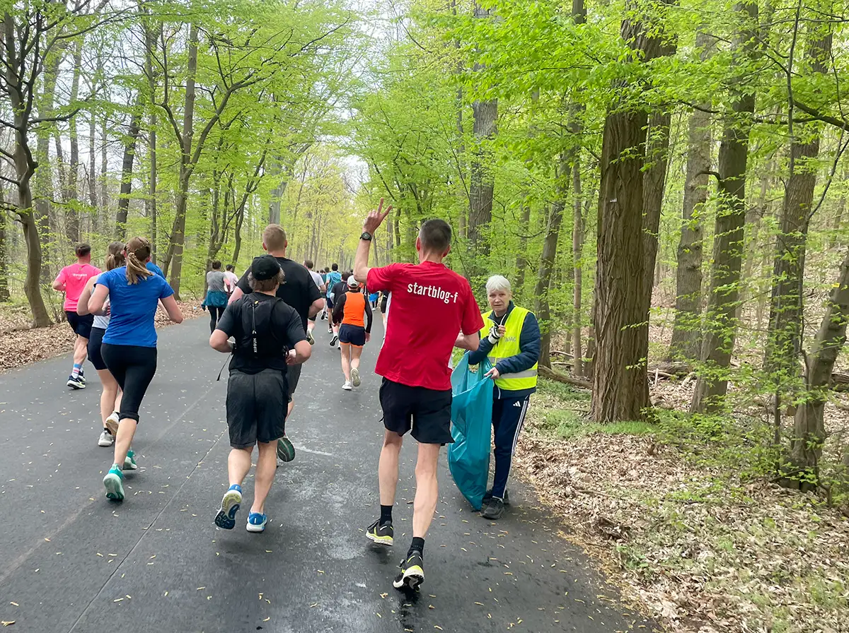 startblog-f-Läufer macht im Vorauslaufen mit den Fingern das Victory-Zeichen