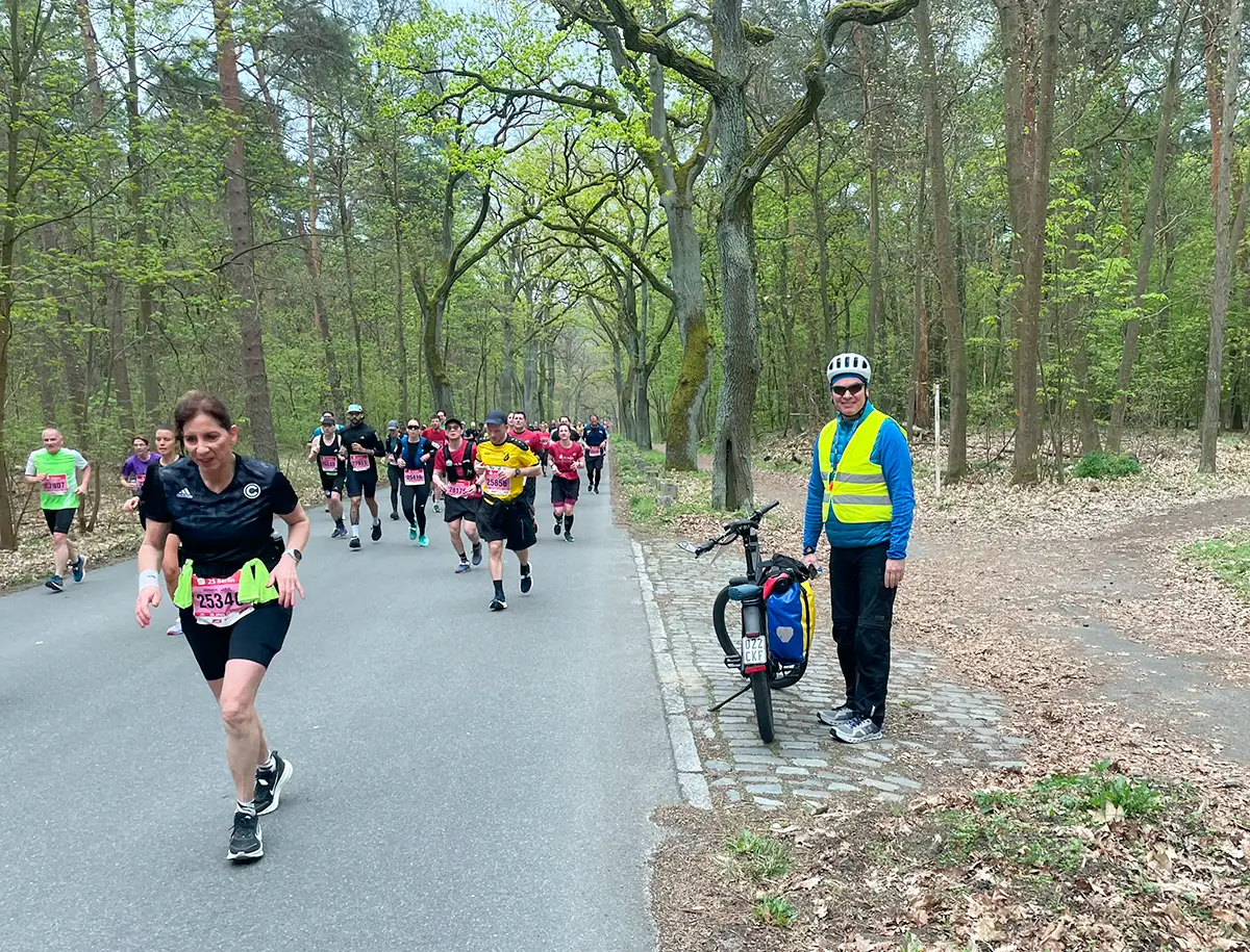 Lächelnder Streckenposten mit Fahrrad am Straßenrand