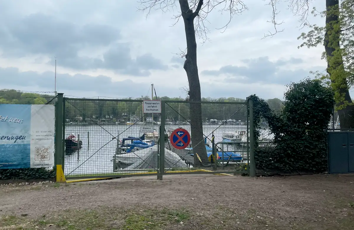 Blick durch einen Zaun auf einen kleinen Yachthafen