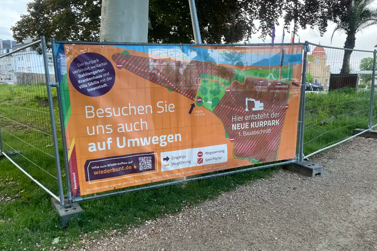 Große Plane an einem Bauzaun mit Bauprojekt „Der neue Kurpark“
