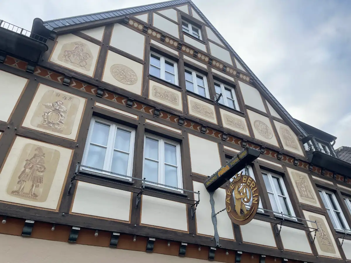 Fachwerkhaus mit Schild „Café Berlin“ mit einem Bären, der eine Brezel hält