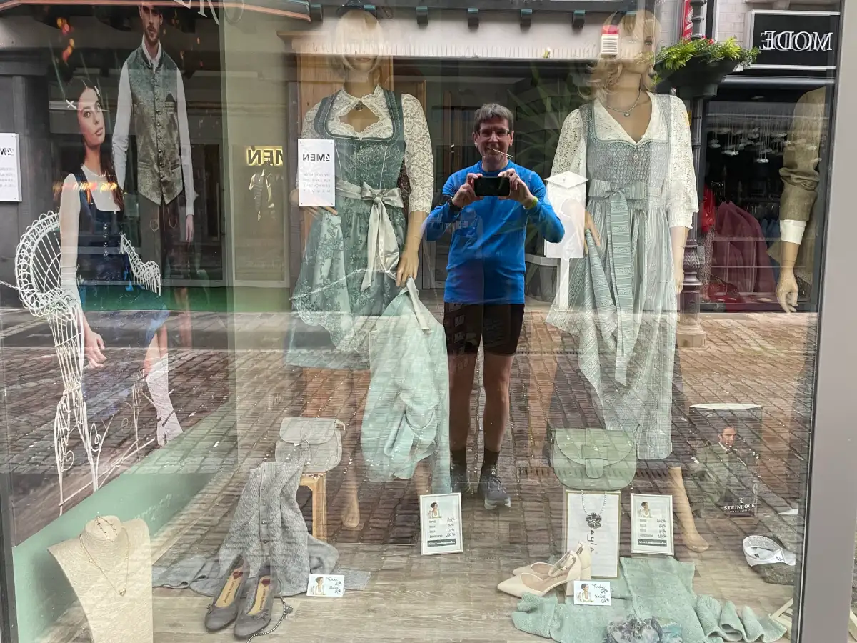 Schaufenster eines Trachtenmode-Geschäfts mit Spiegelung des Läufers