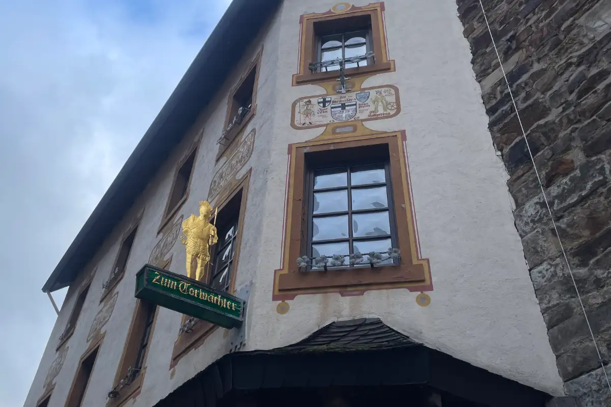 Goldene Figur mit Lanze am Schild „Zum Torwächter“