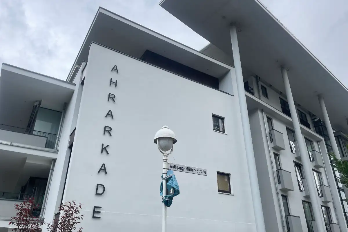 Weißes Neubau-Gebäude mit Metallbuchstaben „AHRKADE“ an der Fassade