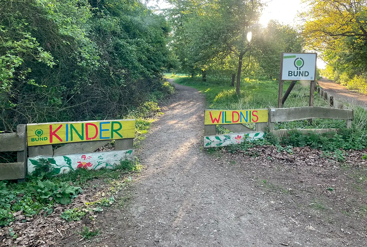 Kleiner Holzzaun mit bunt gemalten Schildern Kinder-Wildnis