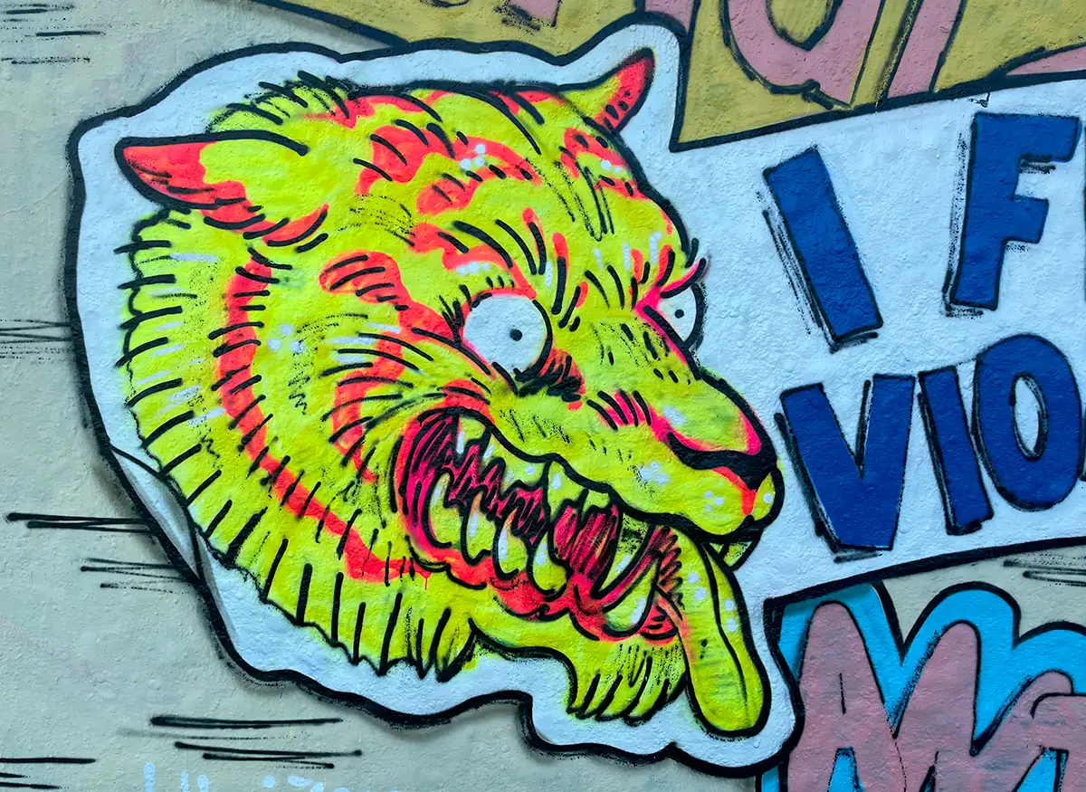 Graffiti eines grellgelben Wolfs mit gefletschten Zähnen