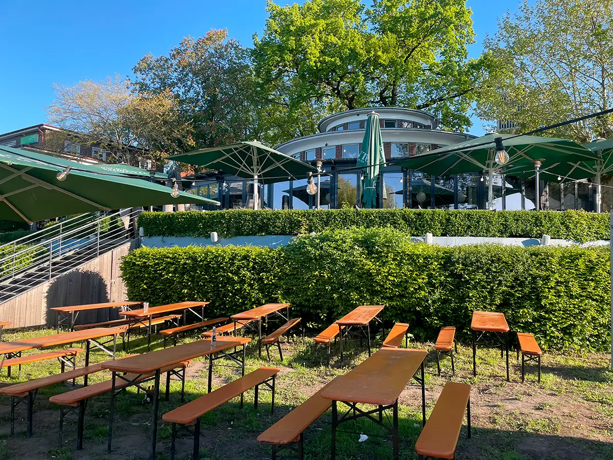 Rundes Café auf einer Anhöhe mit Bänken im Vorgarten