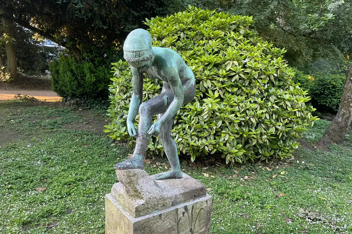 Skulptur Sandalenbinderin in einem Park