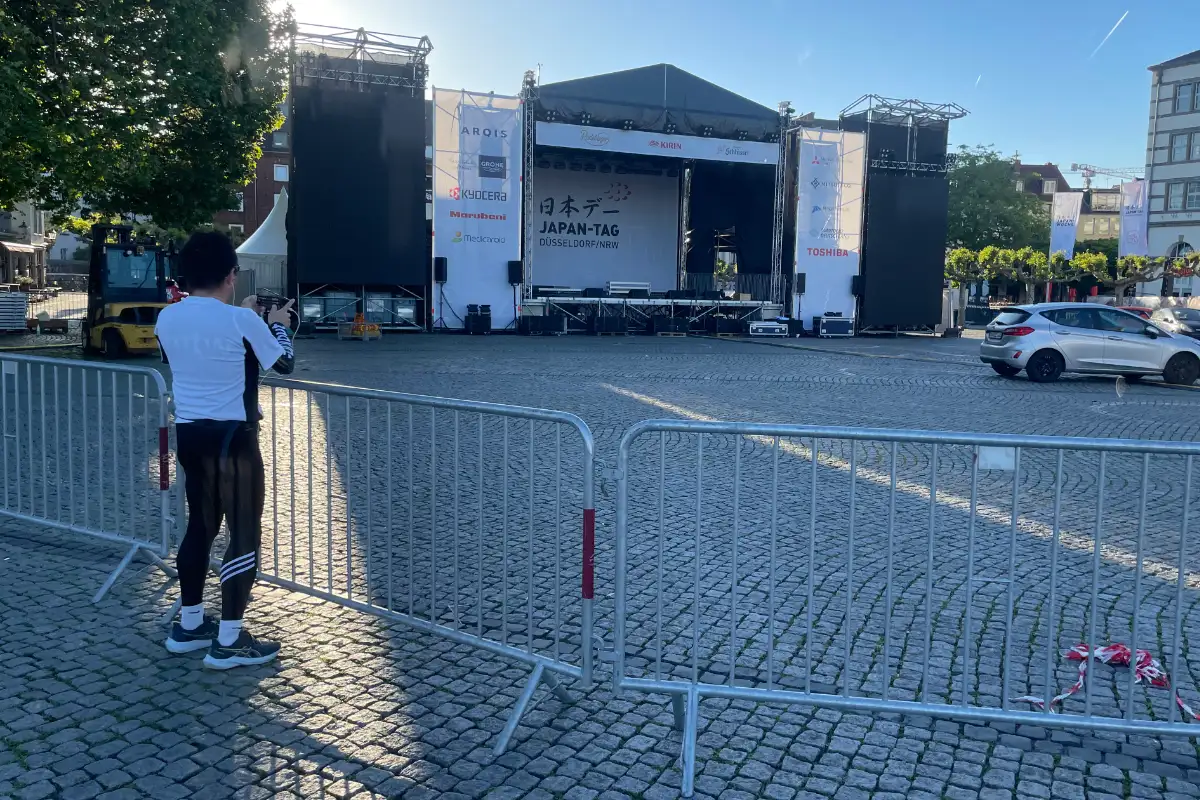 Japanischer Läufer fotografiert die Bühne des Japan-Tags auf dem noch leeren Burgplatz