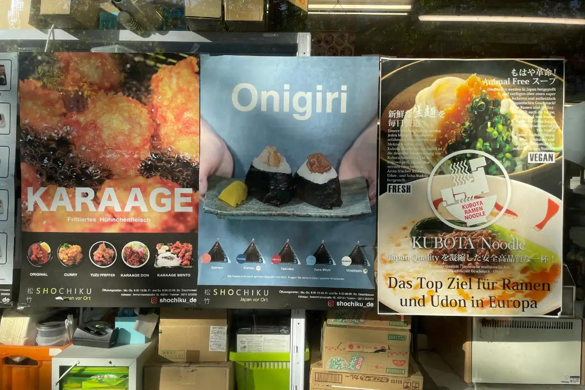 Japanische Plakate für Karaage, Onigiri und Ramen in einem Schaufenster