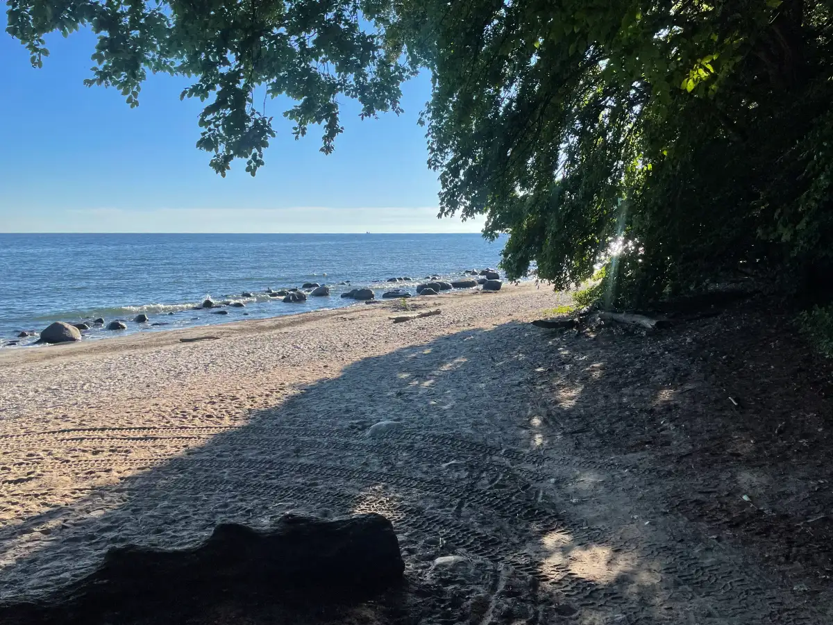Kleiner Strand mit großen Steinen im Wasser