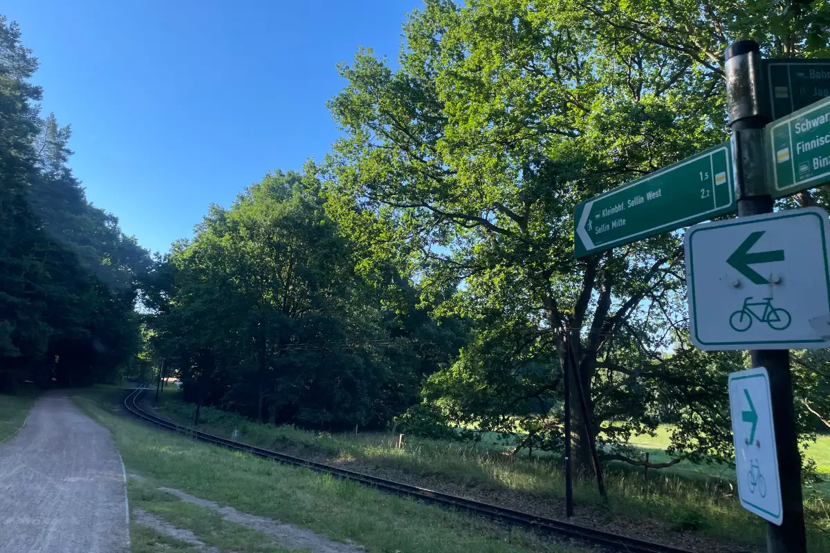 Wegweiser Sellin neben den Bahngleisen der Schmalspurbahn
