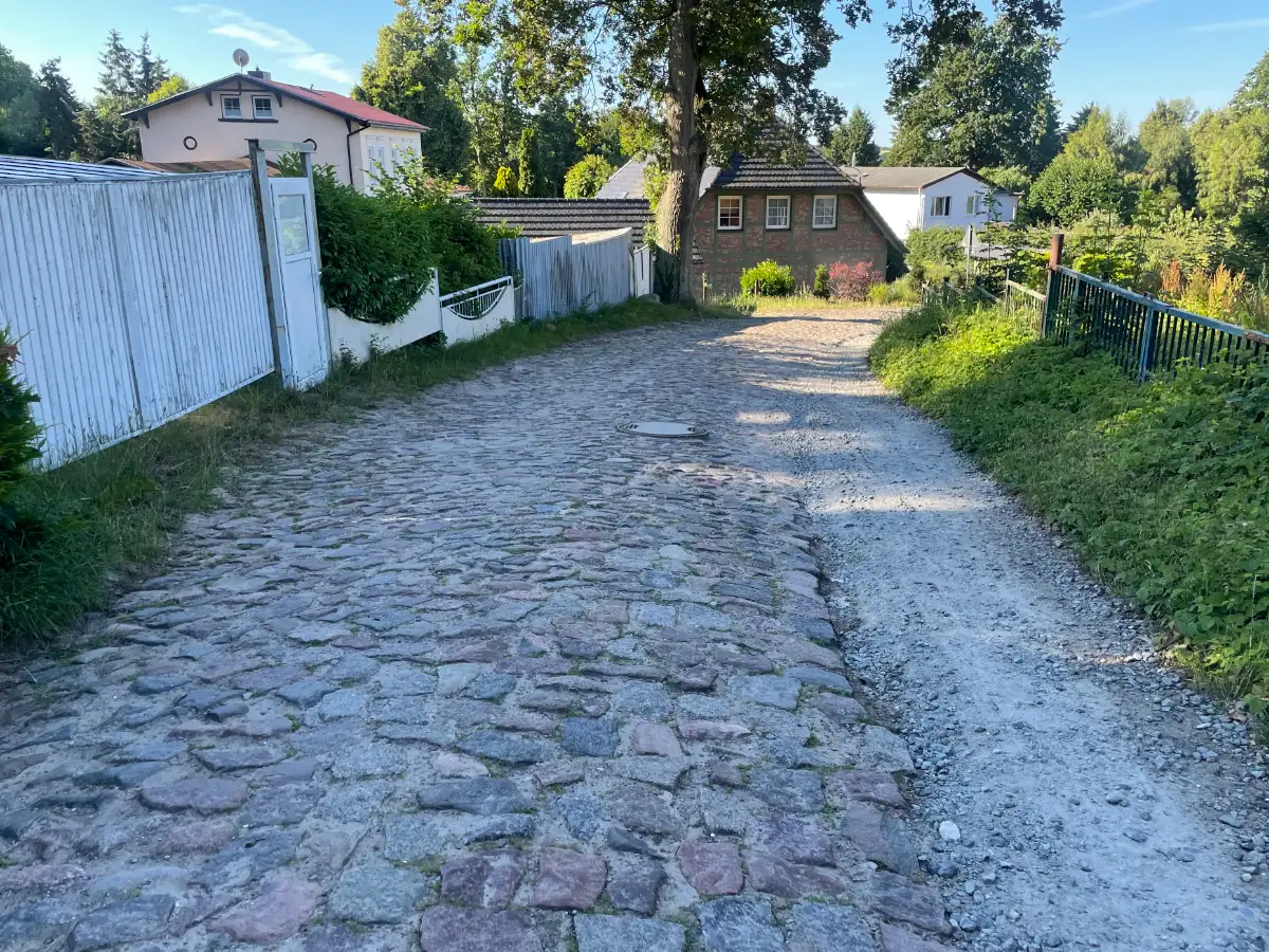 Kopfsteingepflasterte Straße hinunter in den Ort