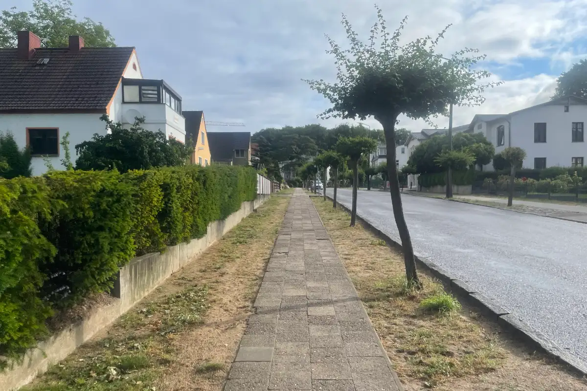 Einfacher Plattenweg neben einer Straße