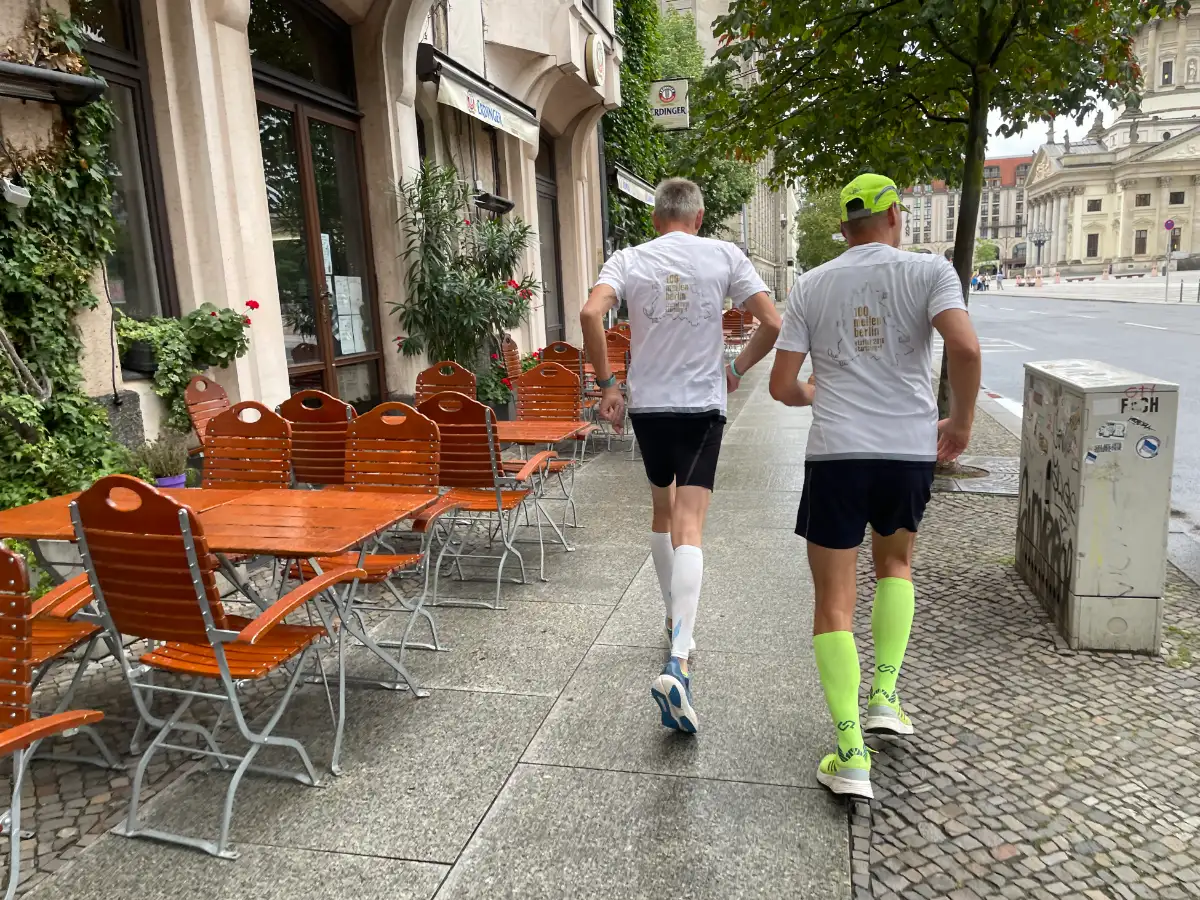 2 Läufer neben Tischen und Stühlen einer Gastronomie