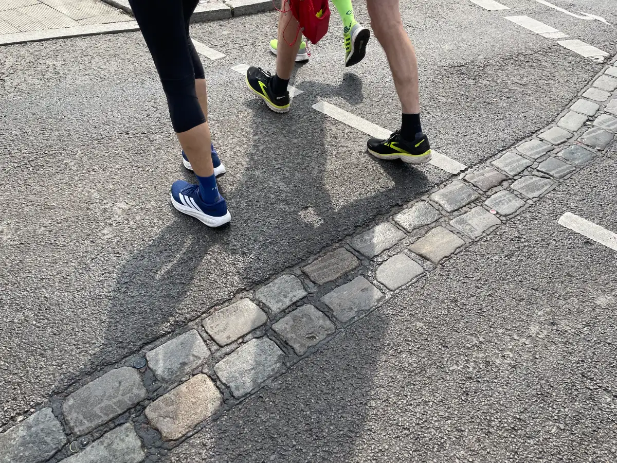 Läuferbeine und die Doppelreihe Kopfsteinpflaster zur Erinnerung an den Mauerverlauf
