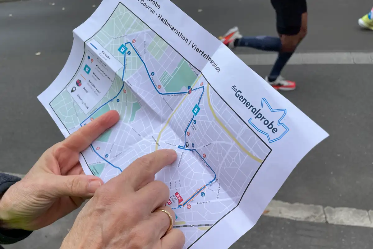 Hände halten den Streckenplan und zeigen auf einen Streckenpunkt