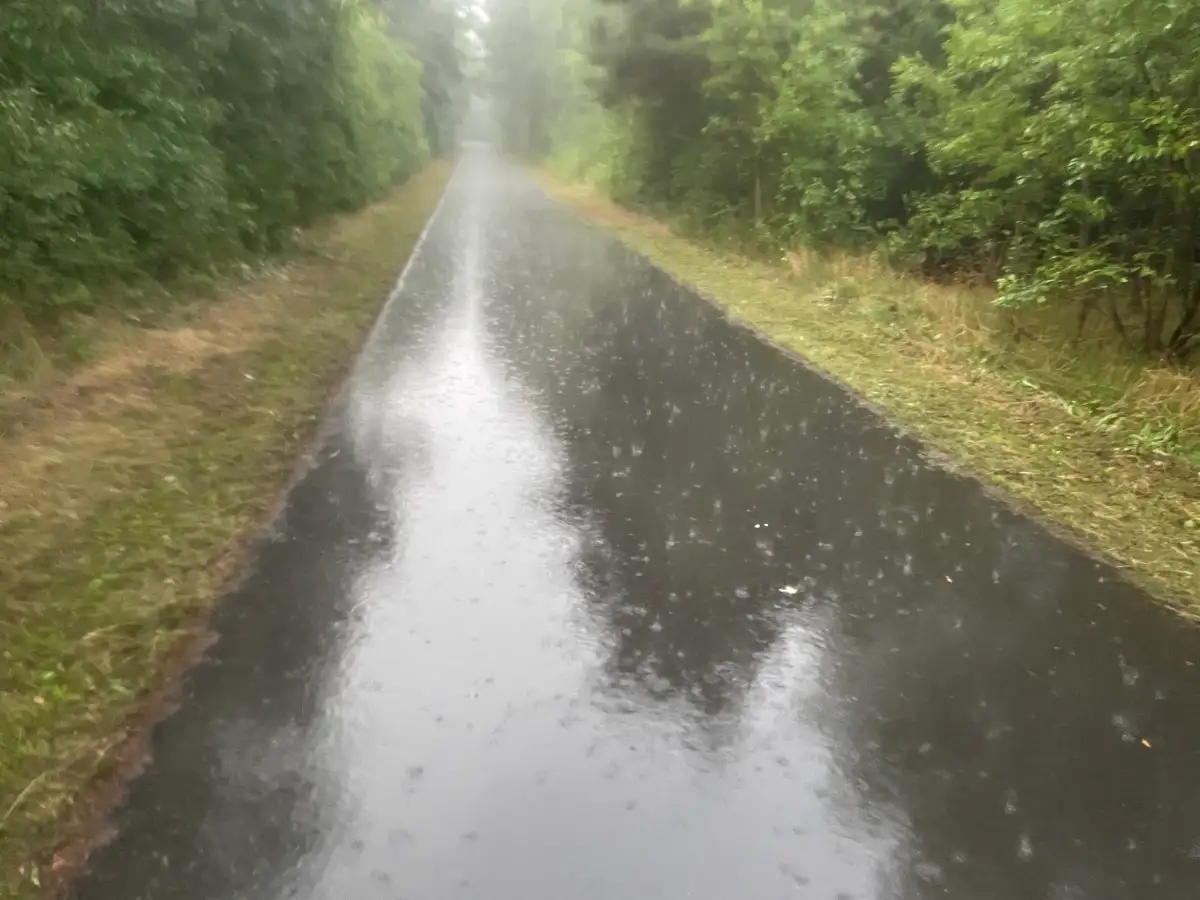 Starker Regenfall auf dem Asphalt des Mauerwegs