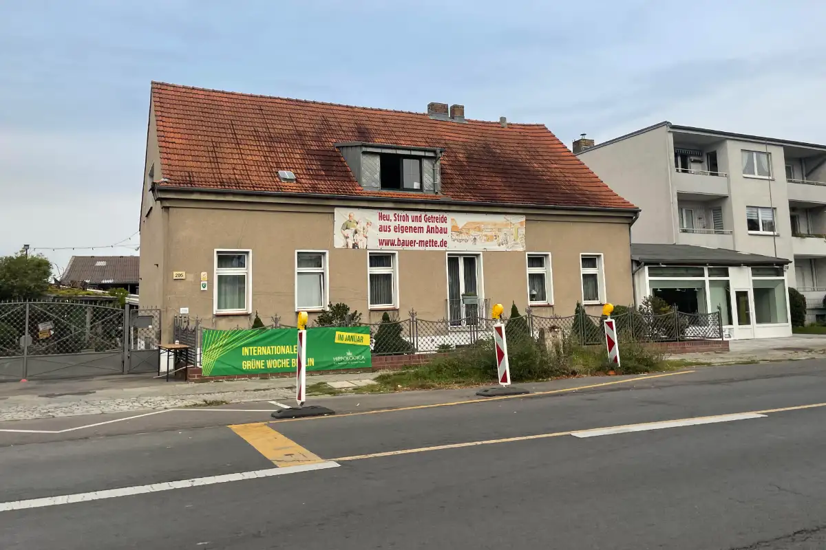 Altes Gebäude an der Straße mit Banner „Heu, Stroh und Getreide aus eigenem Anbau“